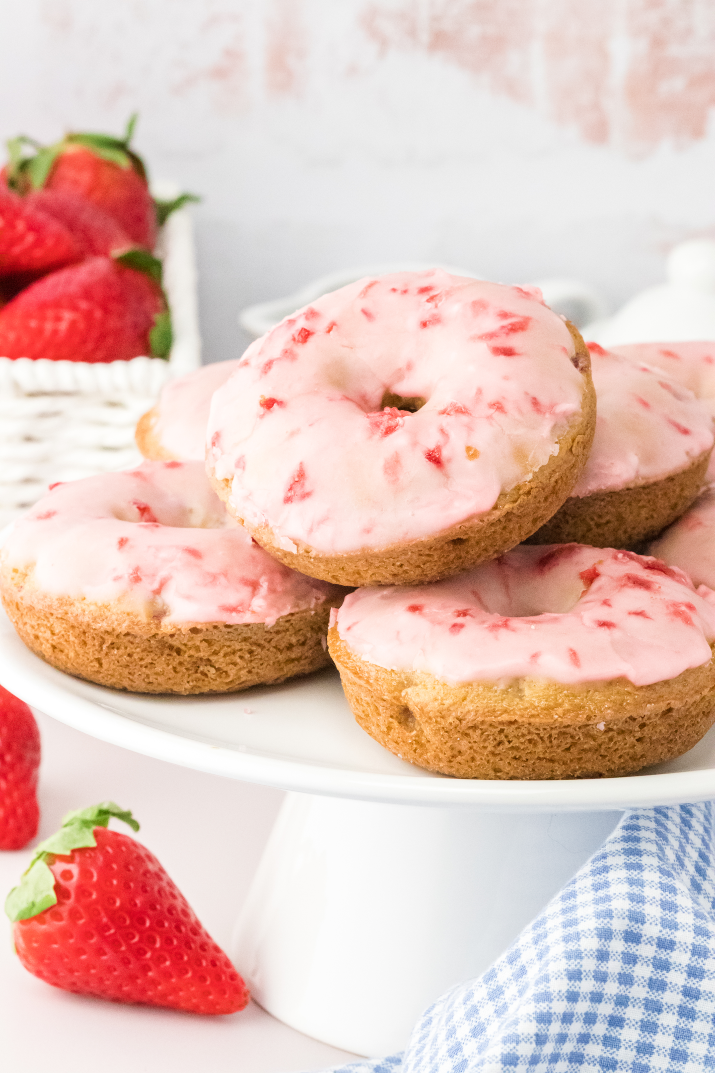 baked strawberry donuts on a cake stand
