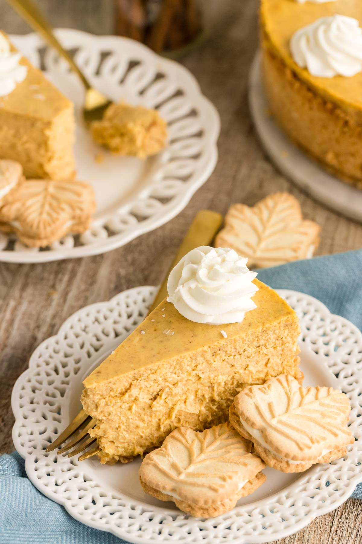 slice of white chocolate pumpkin cheesecake on a plate with two maple cookies