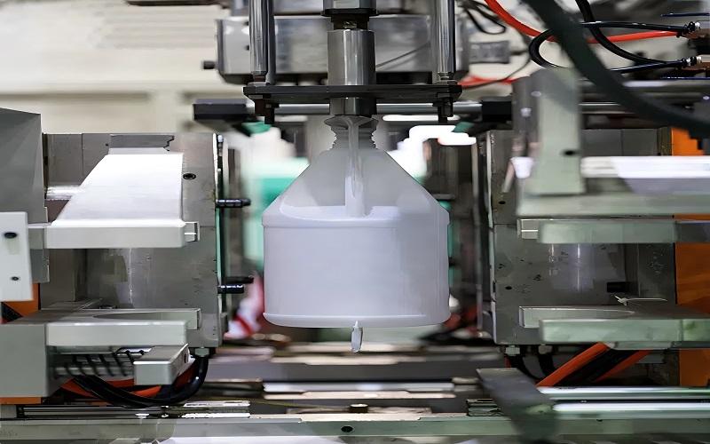 extrusion blow molding machine producing plastic bottles in a manufacturing facility