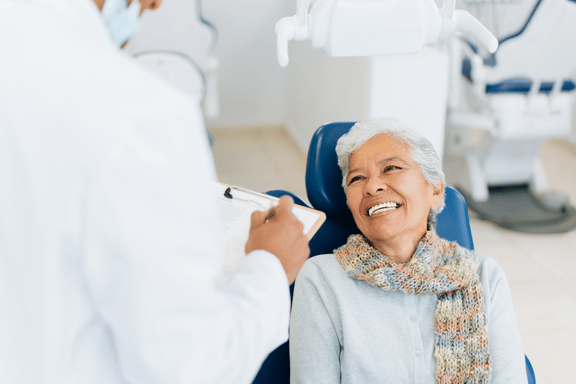 senior female in surgeons chair ready to address her broken teeth with implants