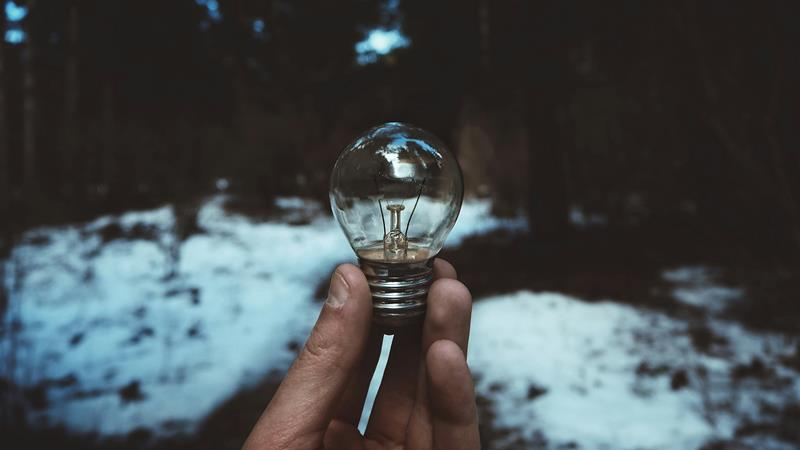 Hand holding incandescent bulb