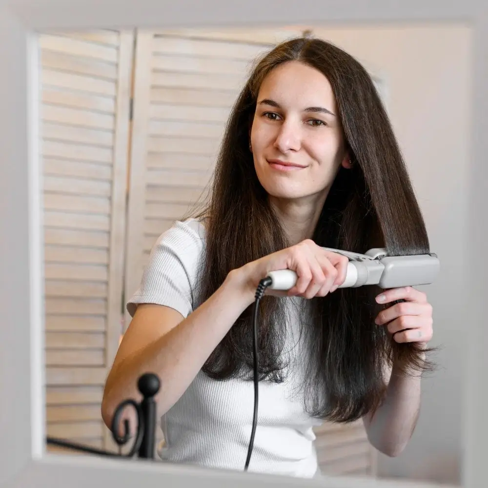 Woman straightening brunette hair