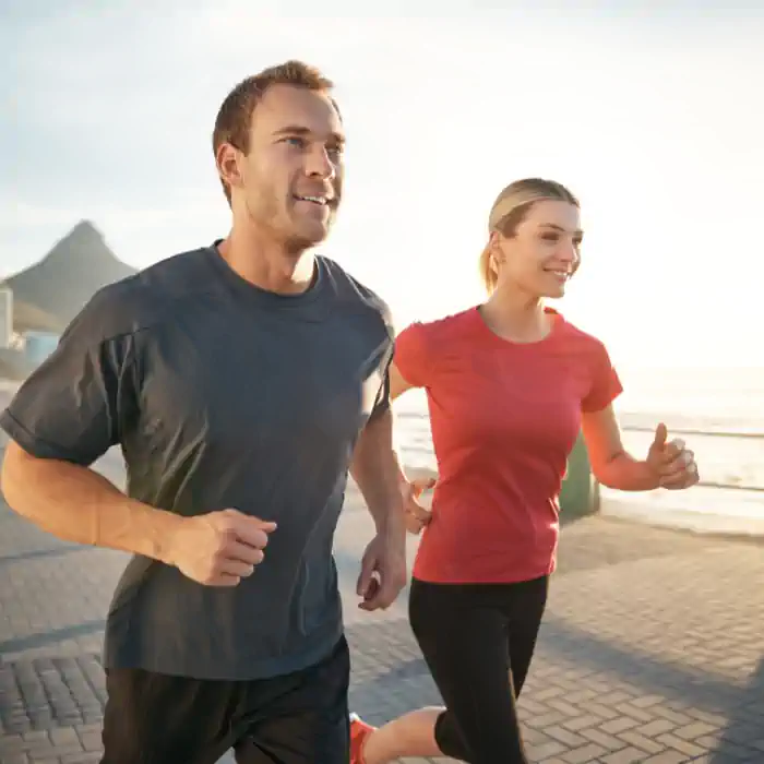  Fit couple jogging by the beach, promoting the CHINAHERB Supplement Collection, which incorporates the five elements theory and supports large intestine health, while encouraging more research, available at The Good Stuff Health Shop South Africa