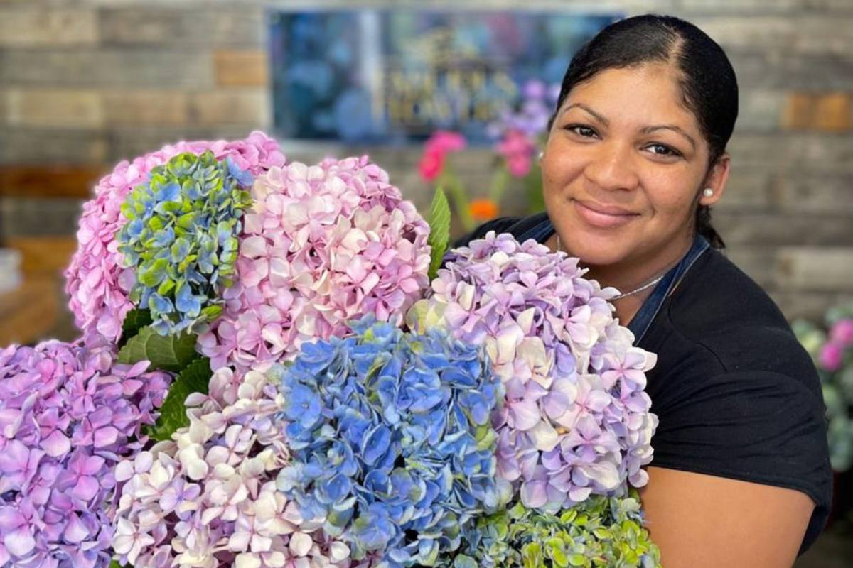 Delivering flowers, bouquet of hydrangeas with local florist smiling. Same Day delivery from Fabulous Flowers.