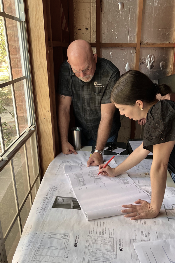 a builder and interior designer chat over blueprints