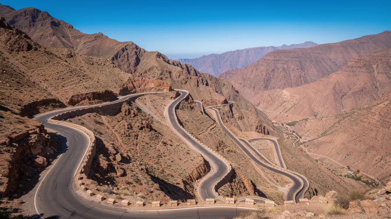 Una carretera de montaña sinuosa a través del Atlas bajo un cielo azul despejado.