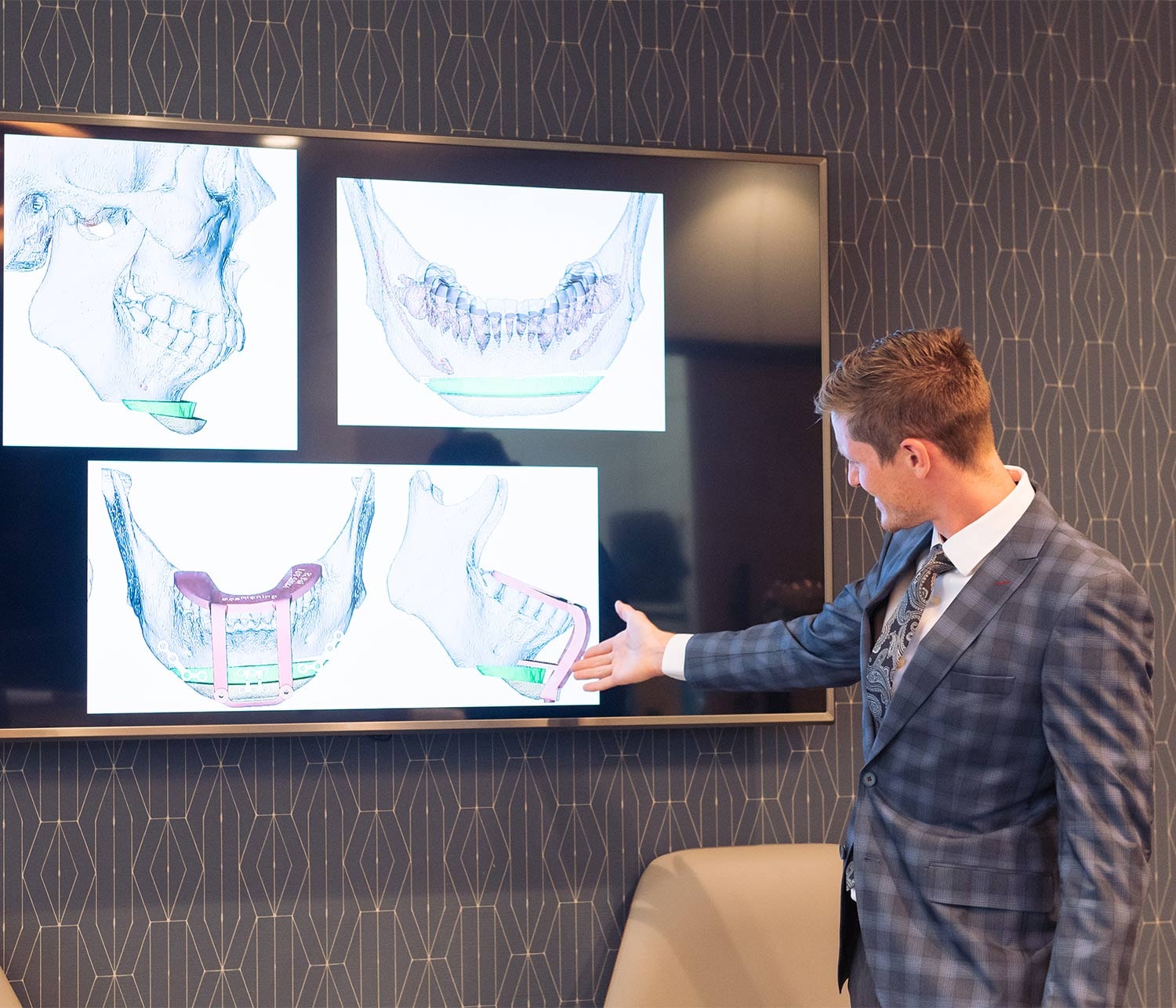 doctor stands in front of large screen of jaw images for virtual surgical planning 