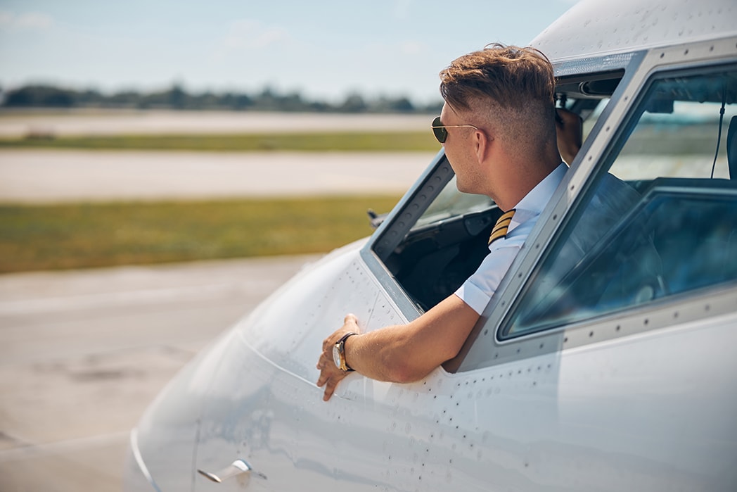 A commercial pilot preparing for a flight in an airline uniform.