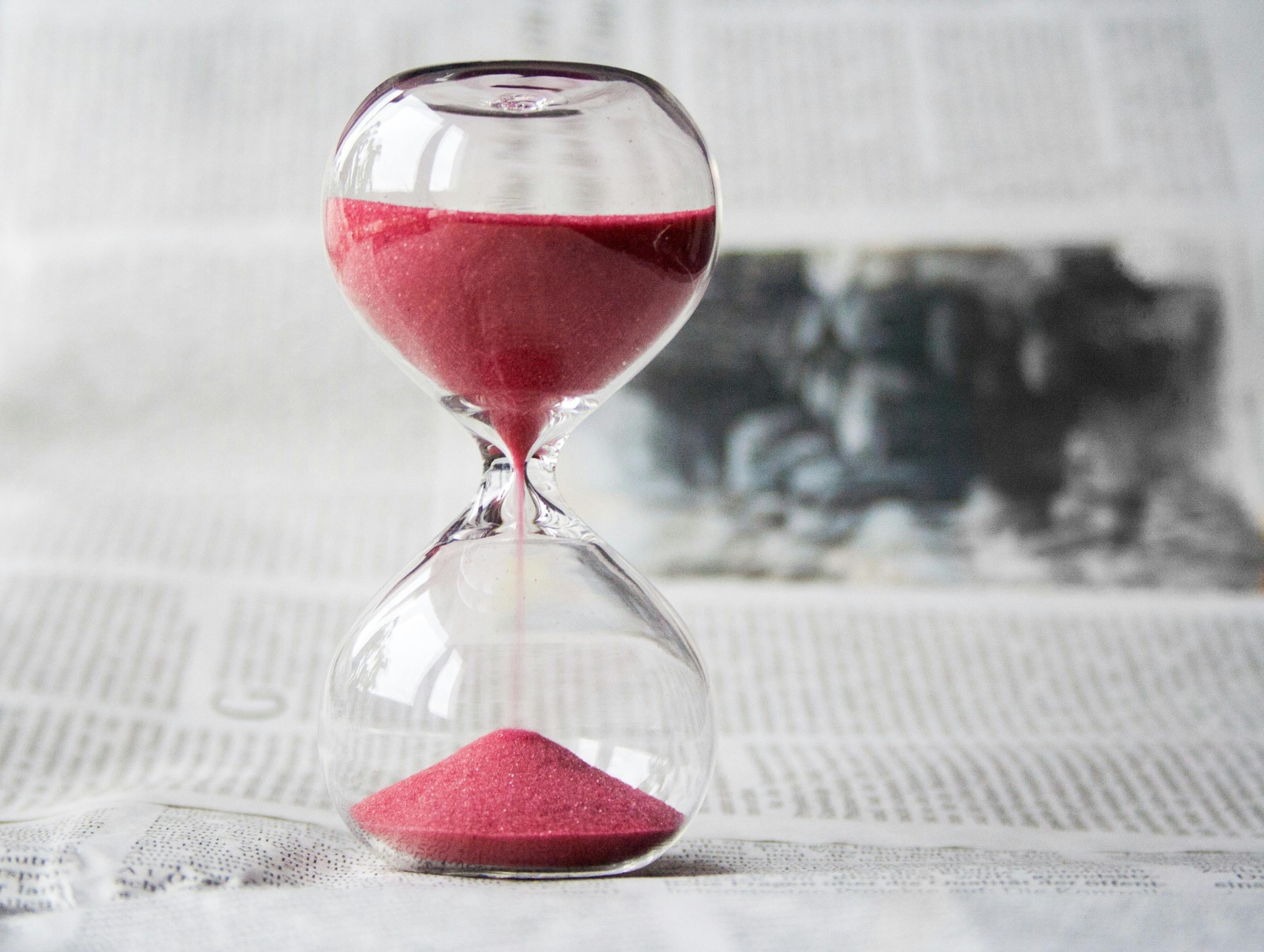 Time passing fast, as shown with sand going through hourglass.