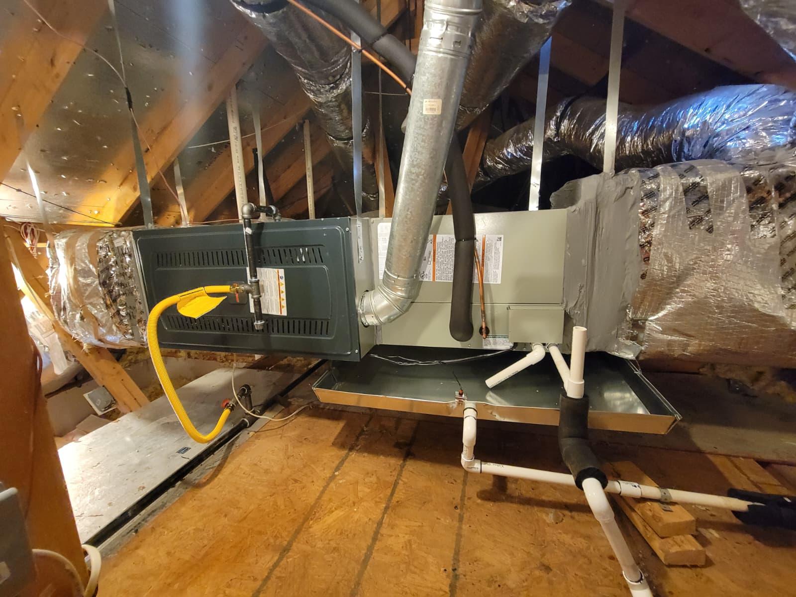 The image depicts the installation of a Trane attic furnace and evaporator coil, showcasing the central air conditioning system being set up in a residential space. This efficient HVAC system aims to provide year-round comfort while optimizing energy savings and reducing cooling costs.