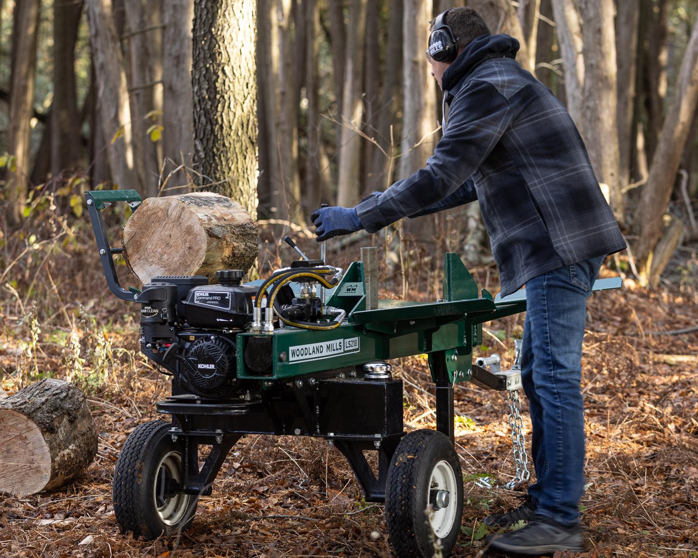A man readying a round on a Woodland Mills log splitter in a forest. 