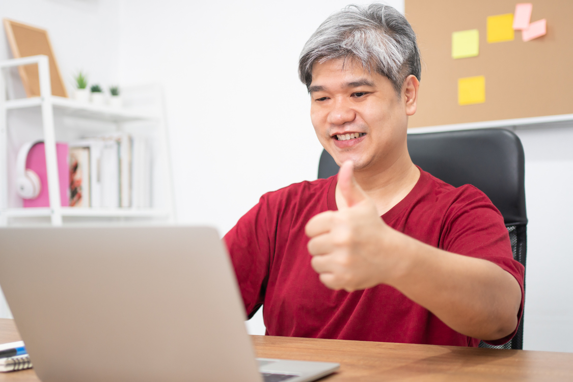 Filipino remote worker smiling and giving a thumbs up during a virtual meeting.