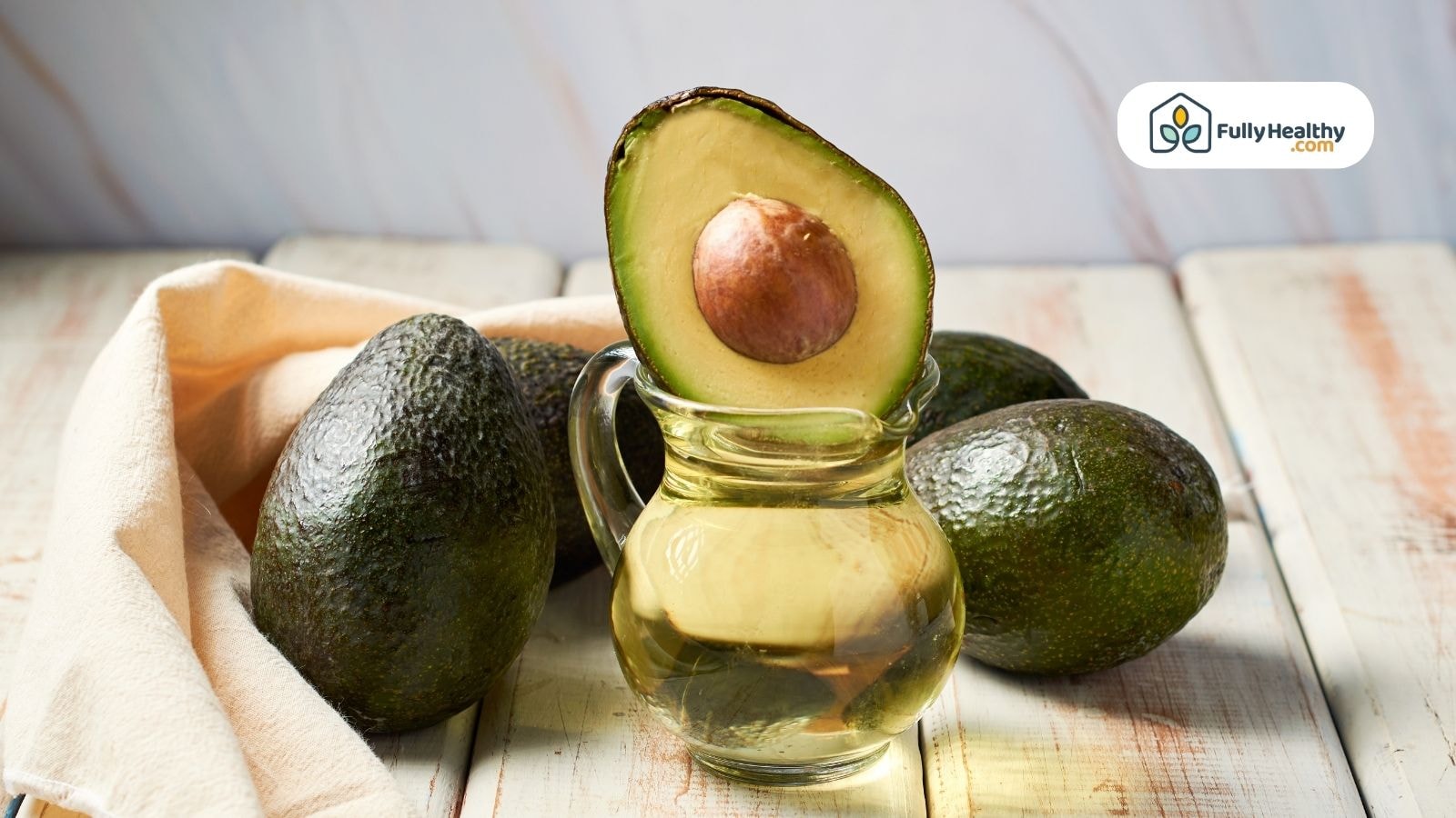 Fresh avocado balanced on jug filled with golden oil