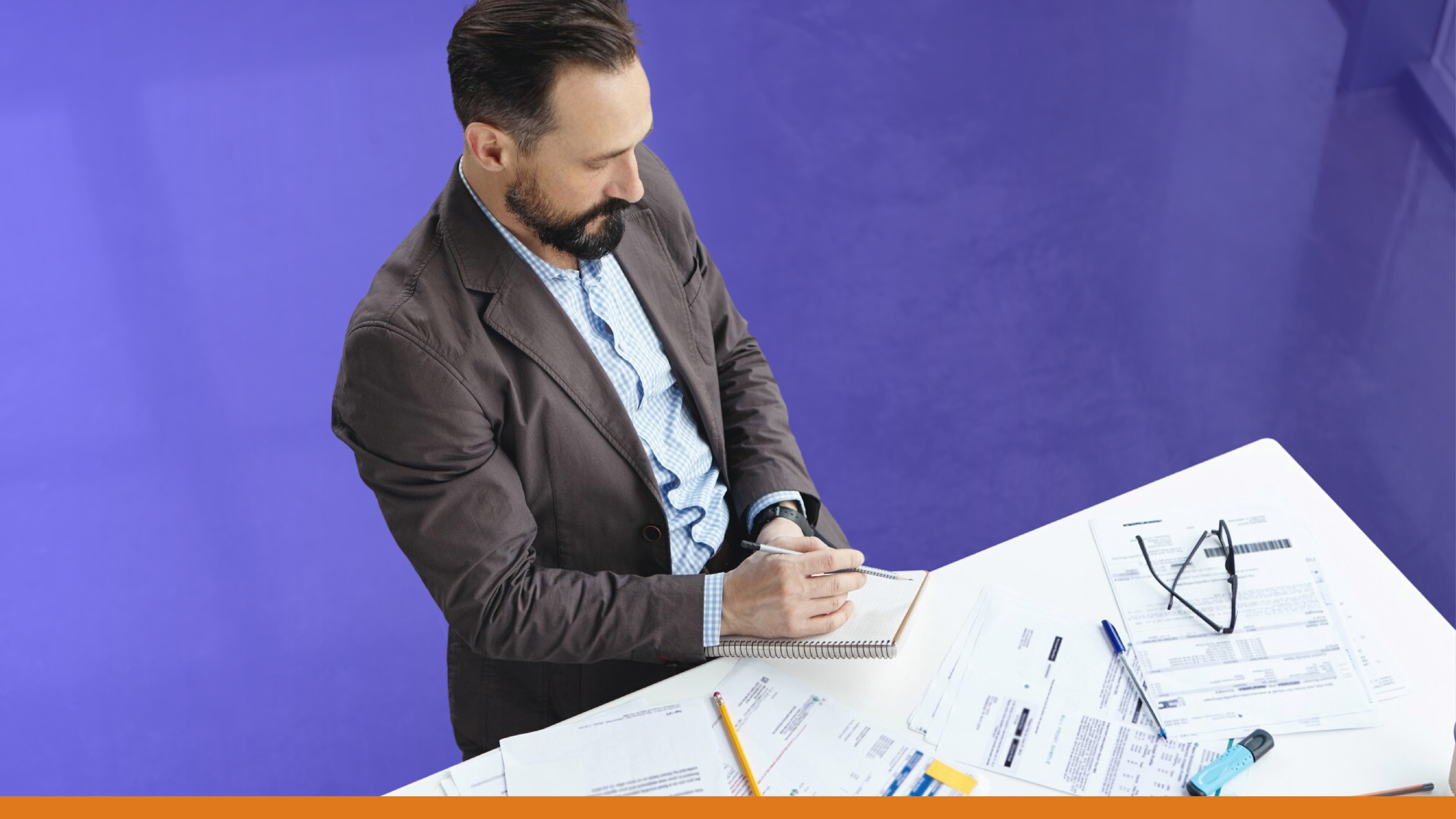Man reviewing paperwork and notes at a desk, highlighting planning for desktop alerts and broadcasting over multiple channels during emergencies.