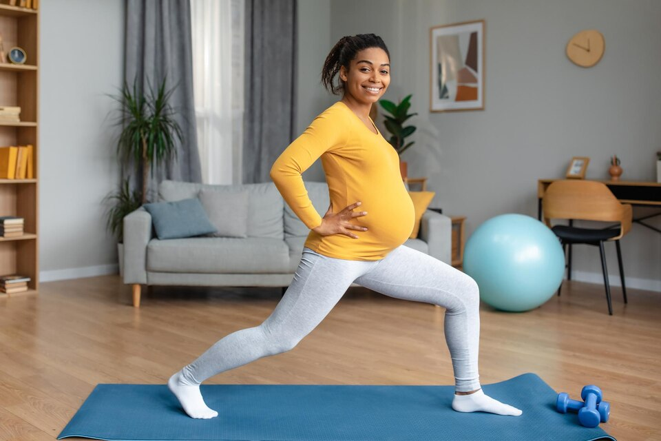 Woman in yellow pregnant exercising to lose weight while she tries to eat healthy foods