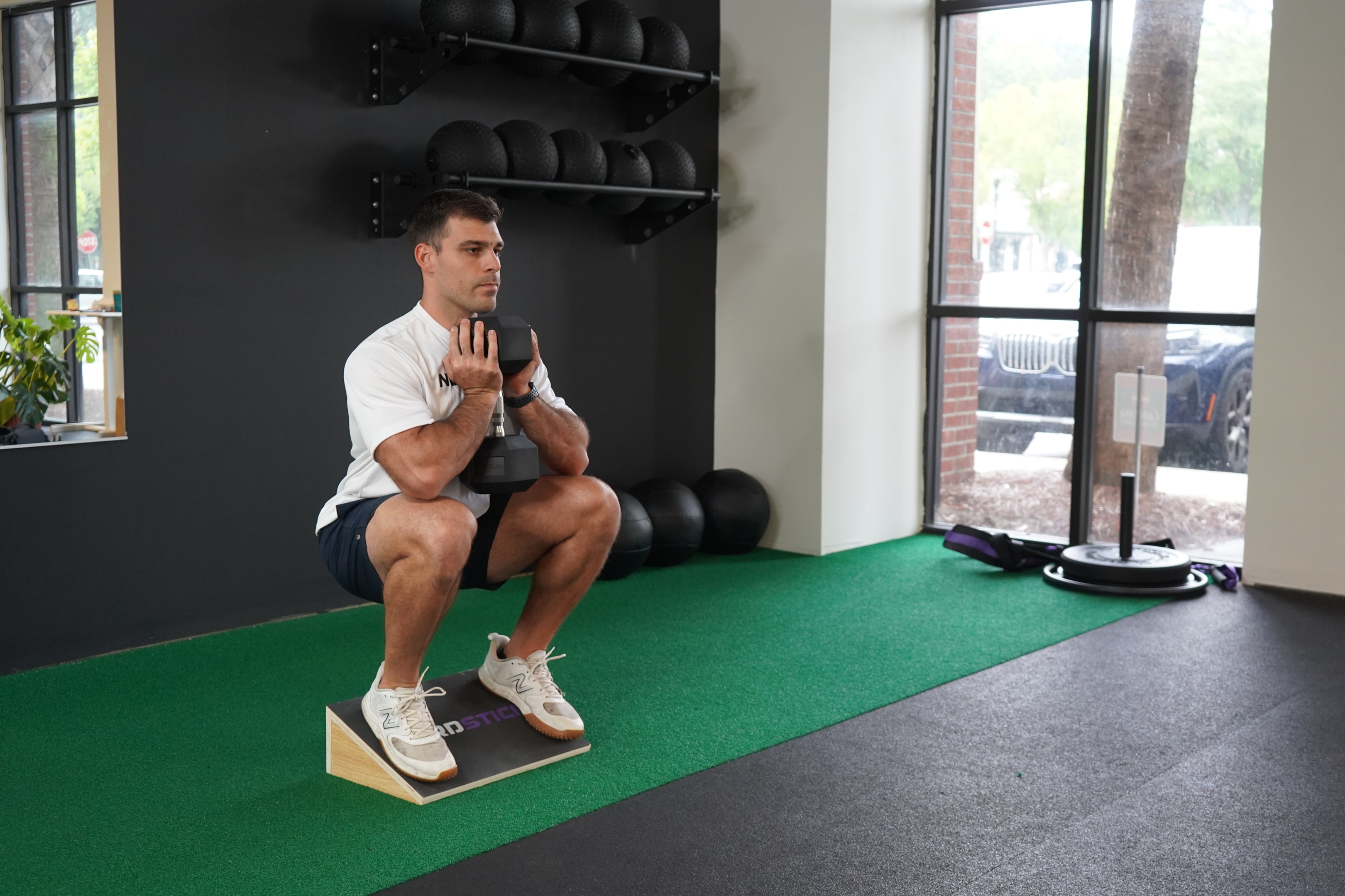 A common equipment in sports medicine, the slant board gives you access to a full range of motion squat while you're still working on your ankle mobility.