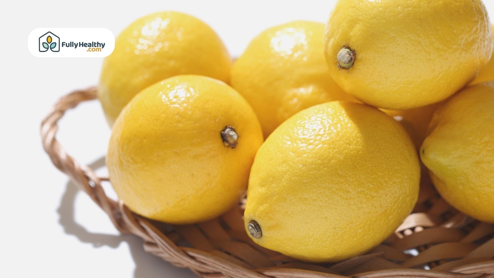 Basket of fresh lemons with shiny peel under bright sunlight