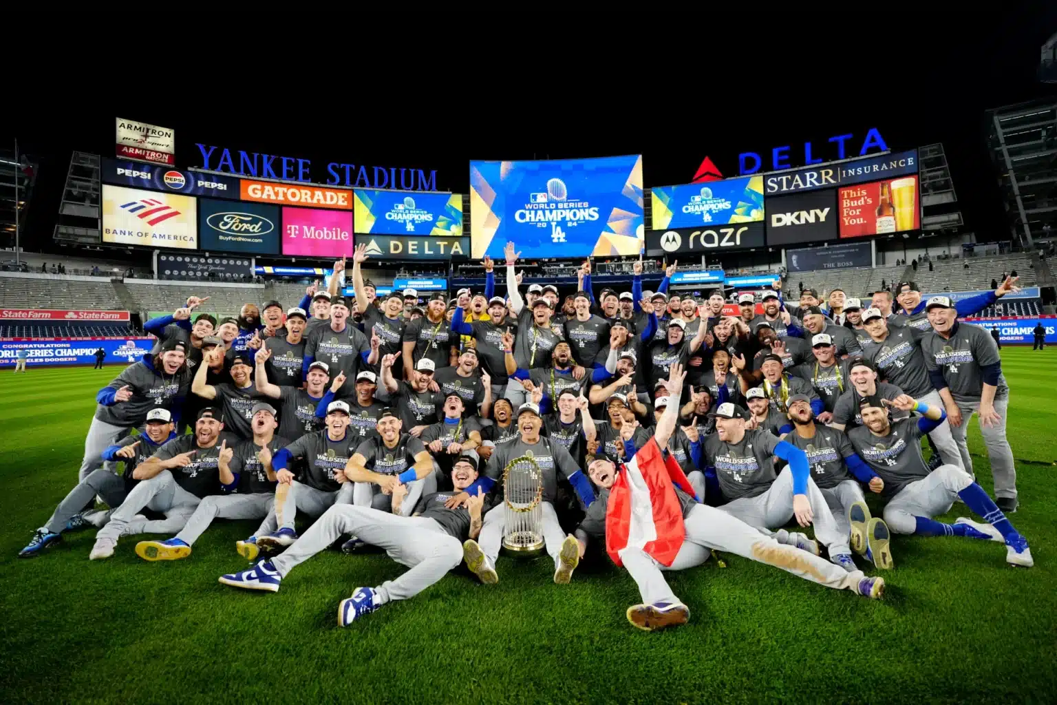 The 2024 Los Angeles Dodgers pose for a team photo with the World Series Trophy after beating the New York Yankees in 5 games.