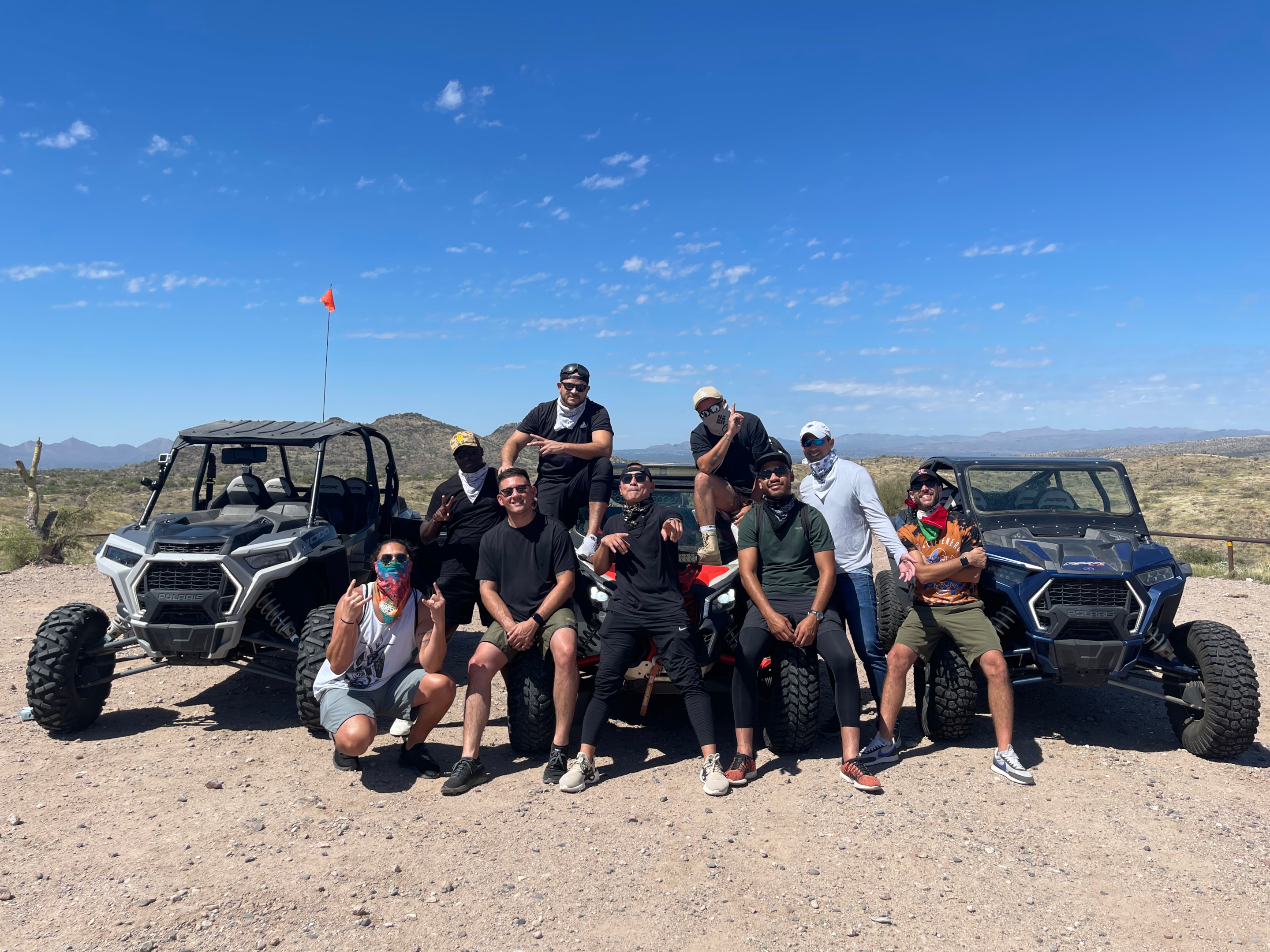 A group of people riding UTVs through the desert landscape of Phoenix, Arizona - the ultimate experience with UTV rentals Phoenix.