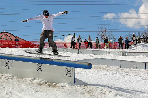 A man snowboarding on a rail at Ruby Hill Rail Yard in Denver 