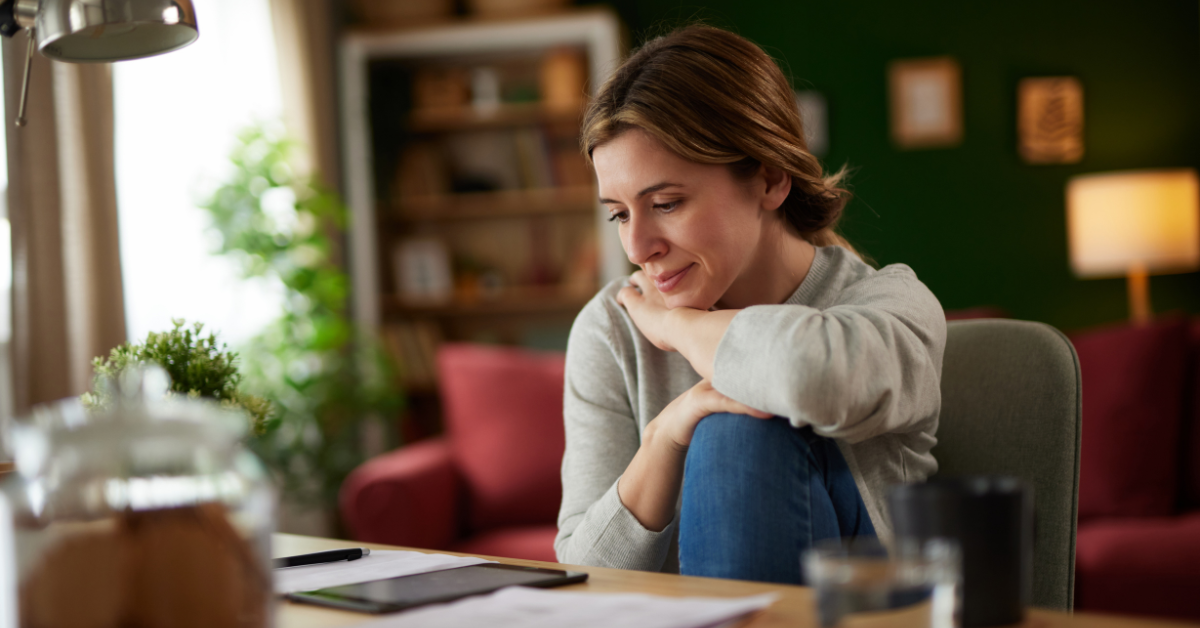 A thoughtful woman at her desk reviewing documents; exploring the tax advantages of LLC.