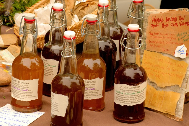 An image of several bottles of apple cider vinegar on a wooden table. 
