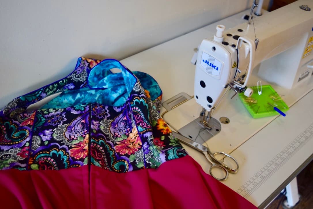image of a dirndl on a dressmaker sewing machine table readdy for altertations to create the perfect fit. seamstress work is important work