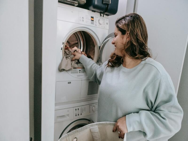 A woman loading the canvas tote bag in the laundry. 