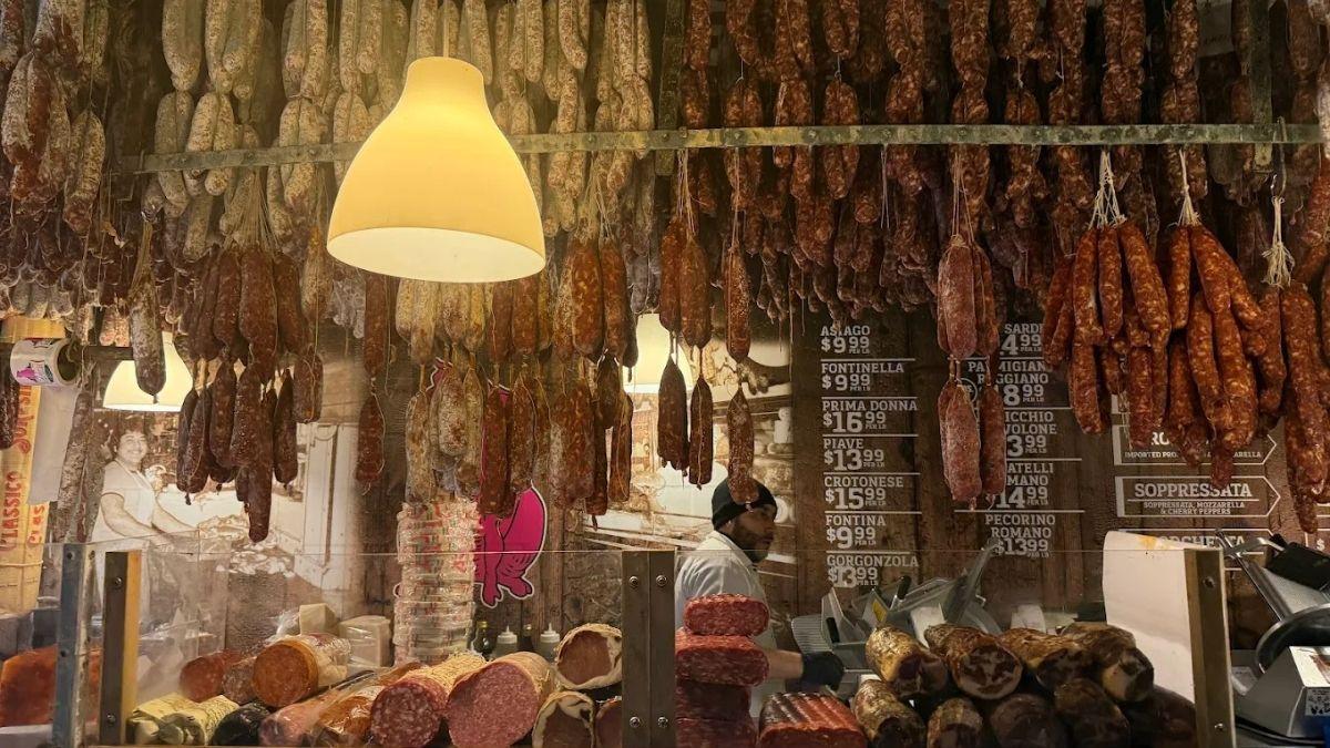 Calabria Pork Store showcasing sausage chandelier, extra hot cured pork, dried sausages and italian staples