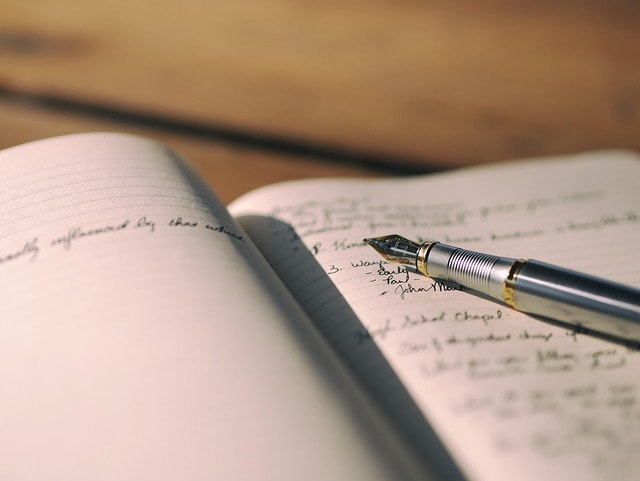 A notebook with a pen on top.