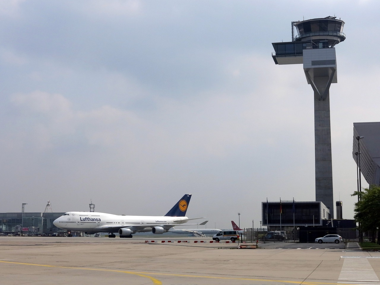 Airport air traffic control tower and a Lufthansa aircraft.
