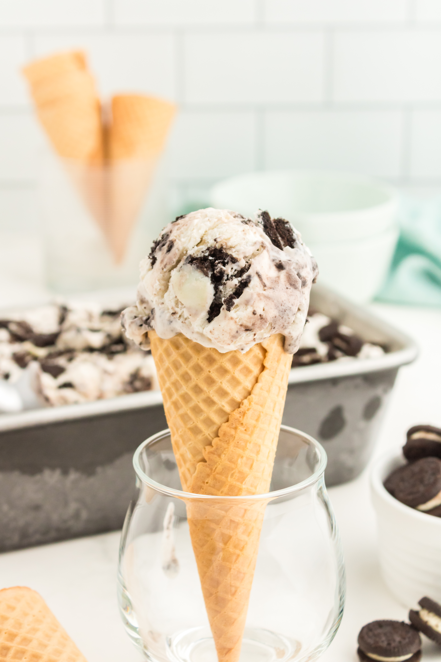 ice cream cone with a scoop of cookies and cream ice cream in a glass