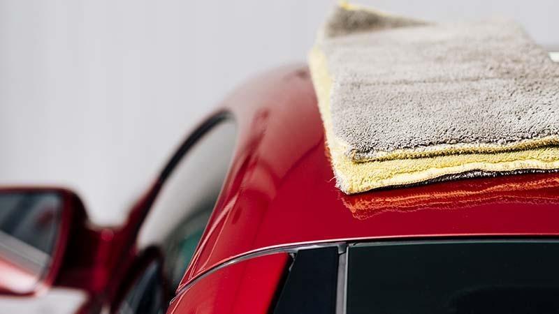 Microfiber towels on a red car roof