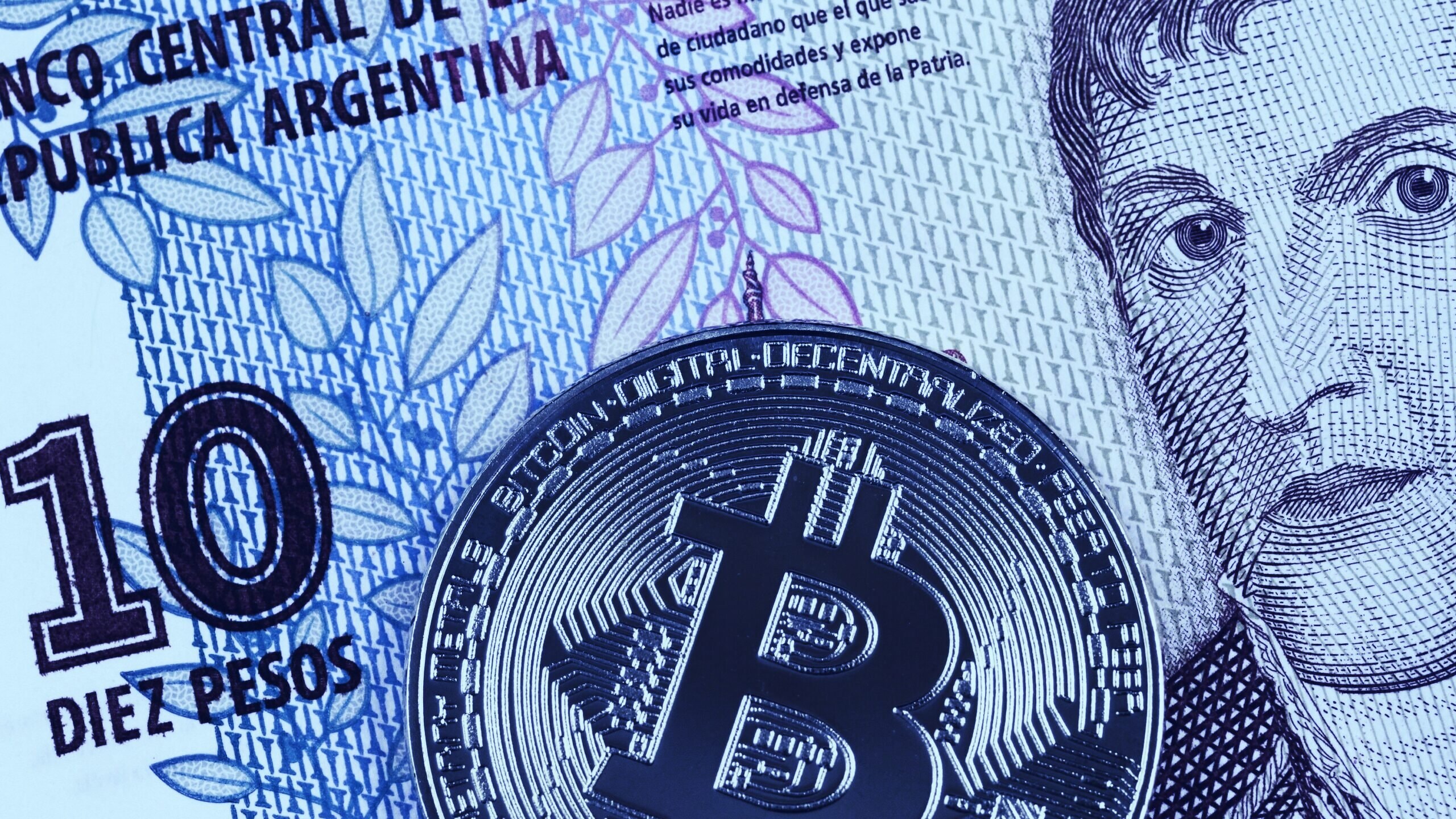 Argentinian Pesos - Market – president – businesses – bitcoin – blockchain – blockchain technology – cryptocurrencies – digital assets  An image of an Argentinian Pesos with a Bitcoin logo on top of it.