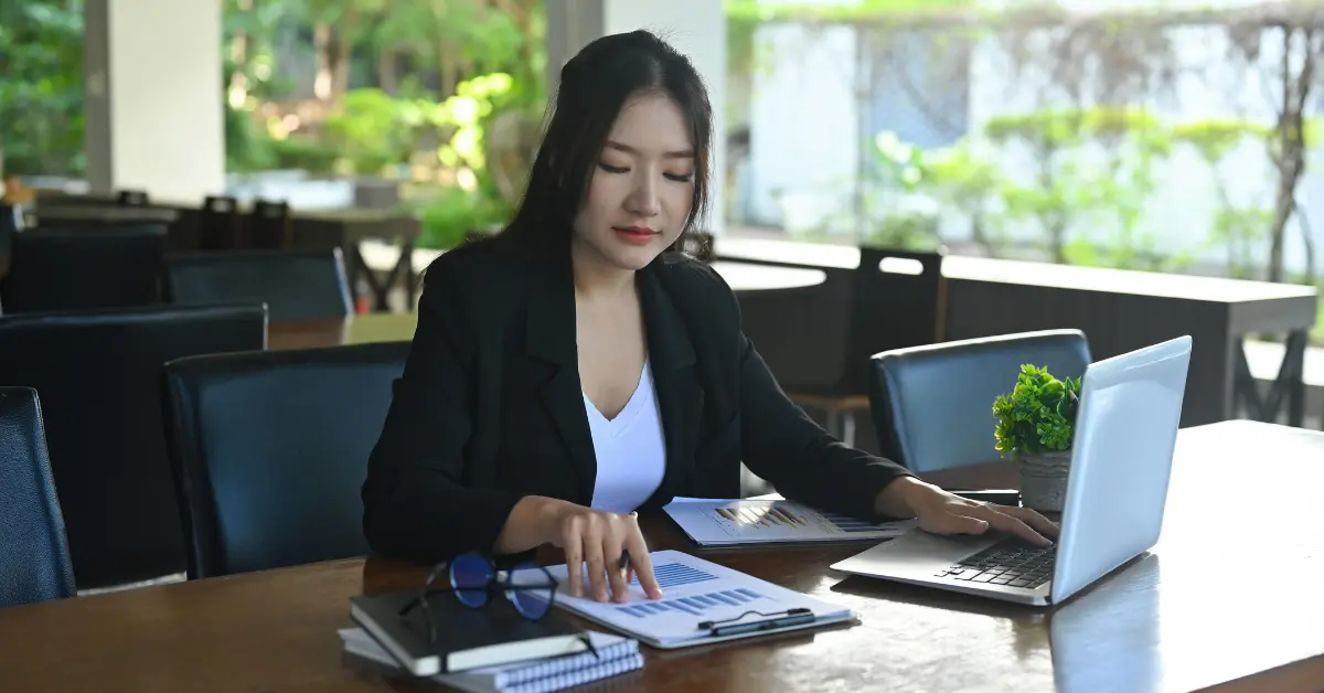 How to create a holding company? Woman reading documents for the process of setting up a holding company.