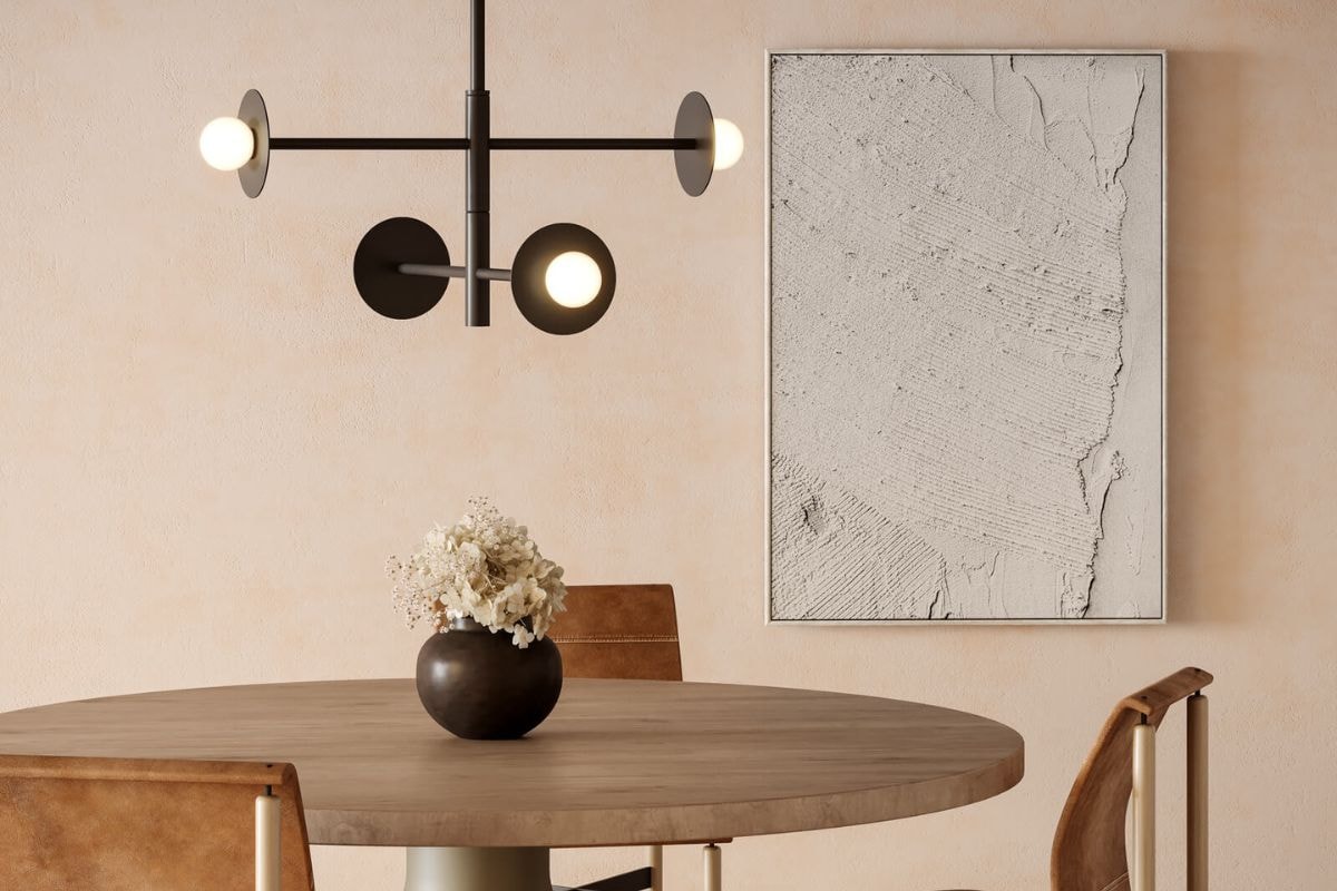 Minimal dining space with the Kuzco Nodes Large Linear chandelier hanging above a round wood table and neutral artwork.