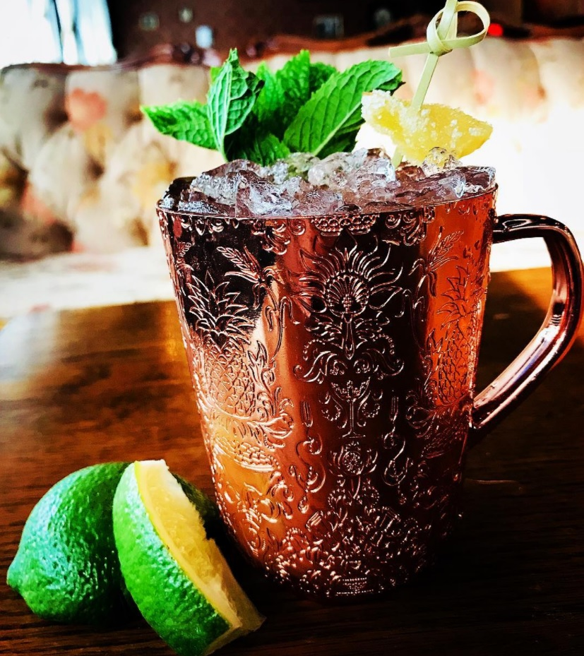 cold drink in a bronze mug filled with ice and garnished with mint leaves