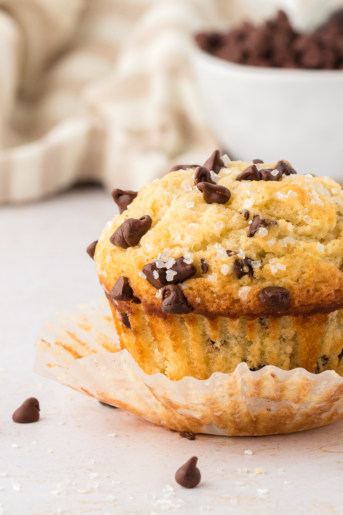 chocolate chip muffin with a paper liner peeled away