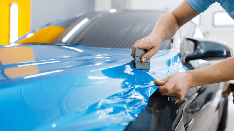 A man is applying the car wrap.