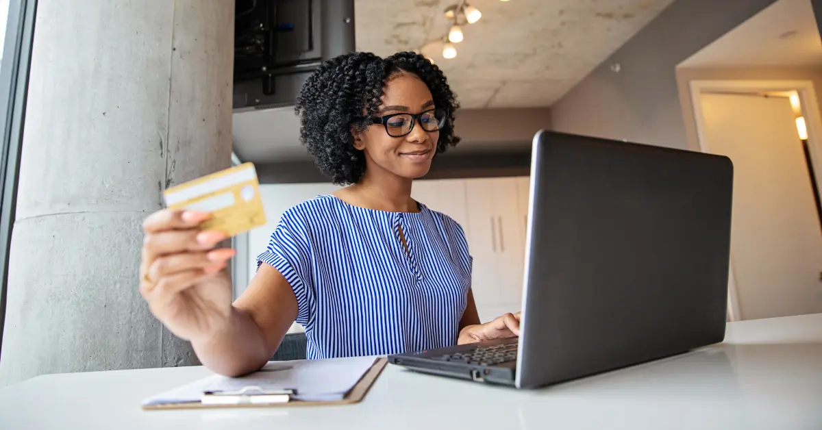OnlyFans creator at desk viewing her laptop with payout notification, showing how long does OnlyFans payout take.
