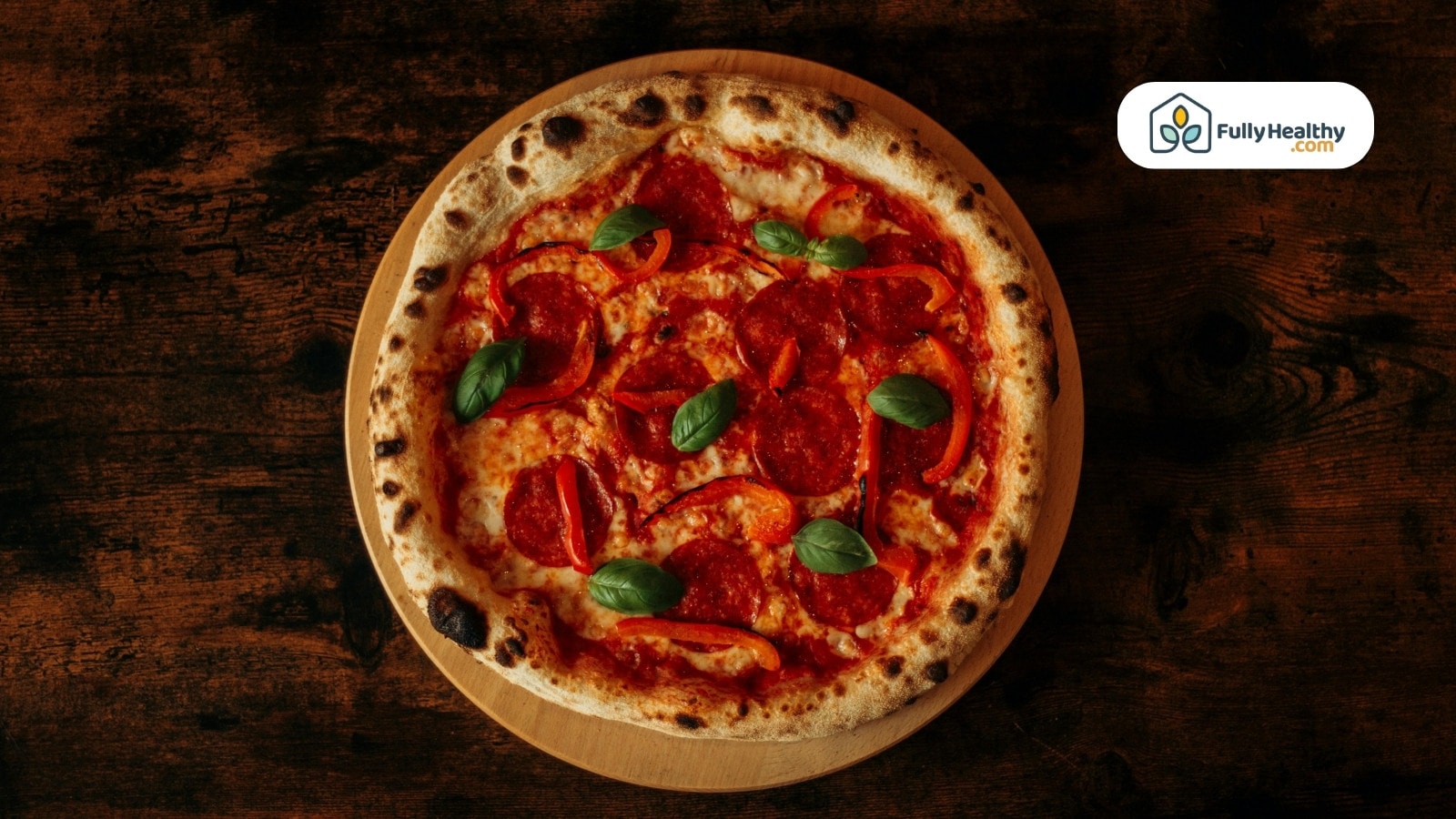 Pepperoni pizza with basil leaves on wooden board top view