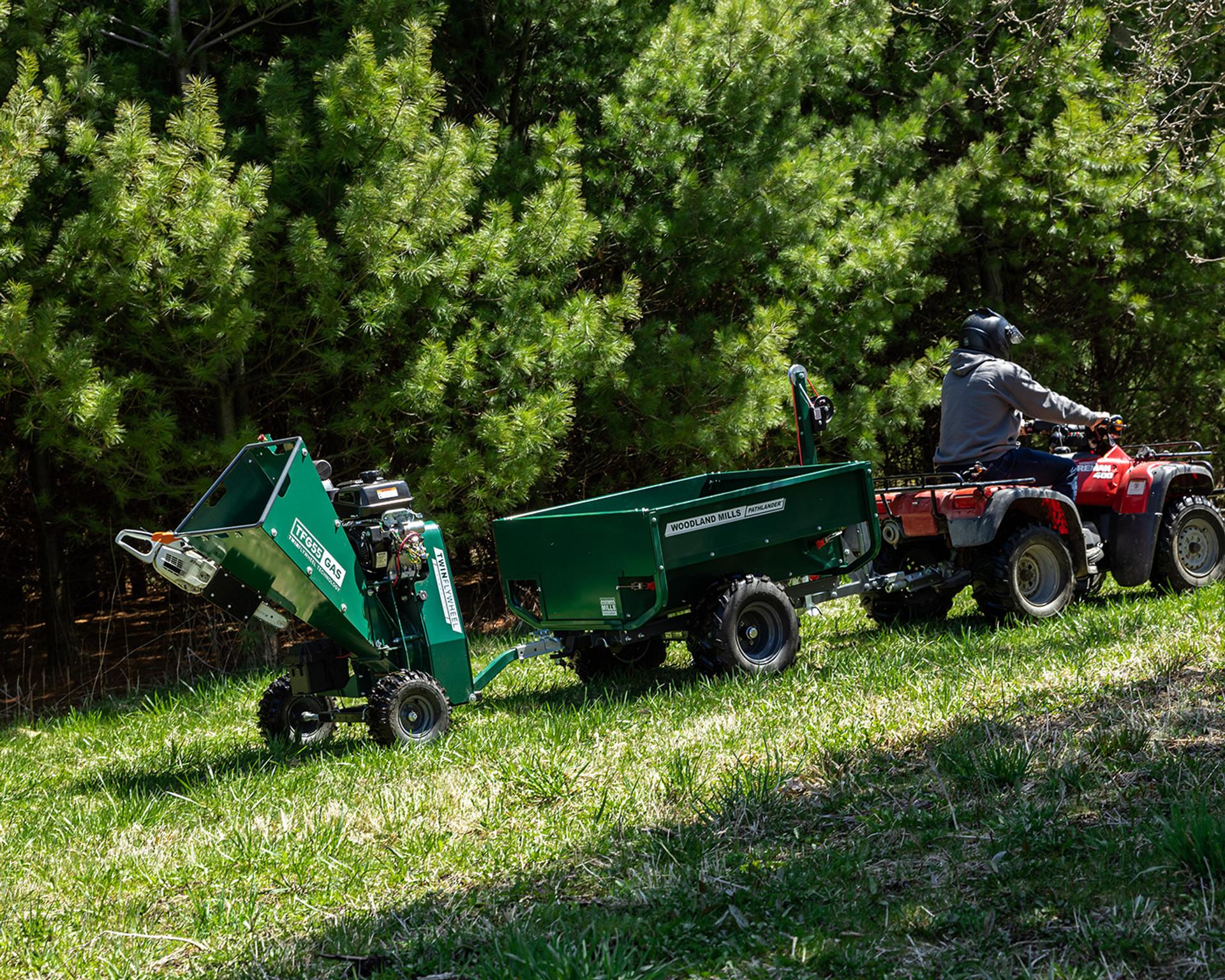 A Woodland Mills wood chipper attached to a trailer attached to an ATV.