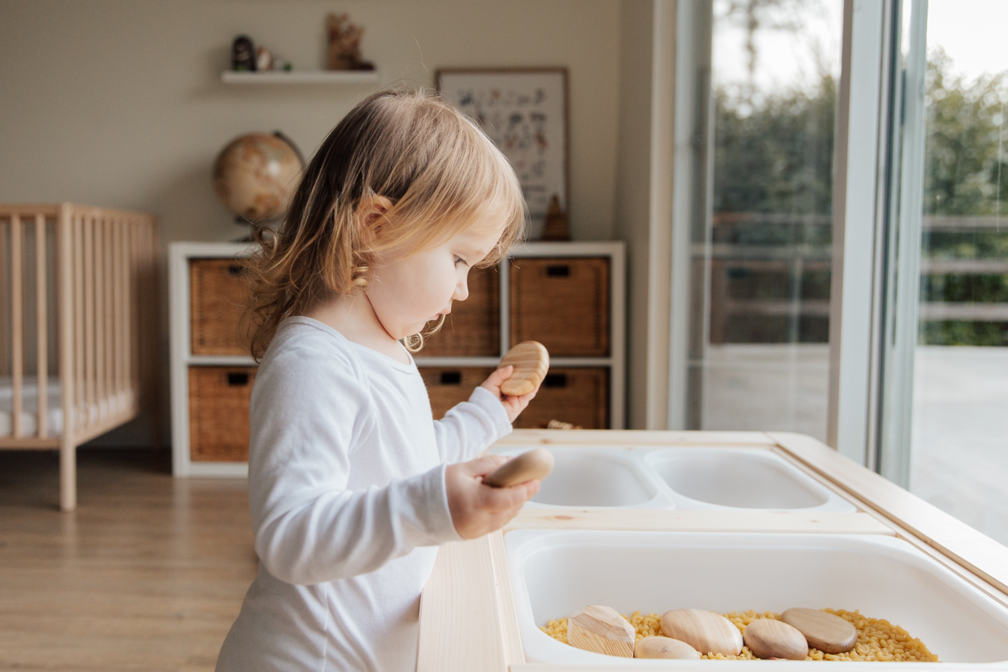 Sensory Play | Photo by Tatiana Syrikova from Pexels | https://www.pexels.com/photo/cute-little-girl-playing-with-stones-near-table-at-home-3933073/