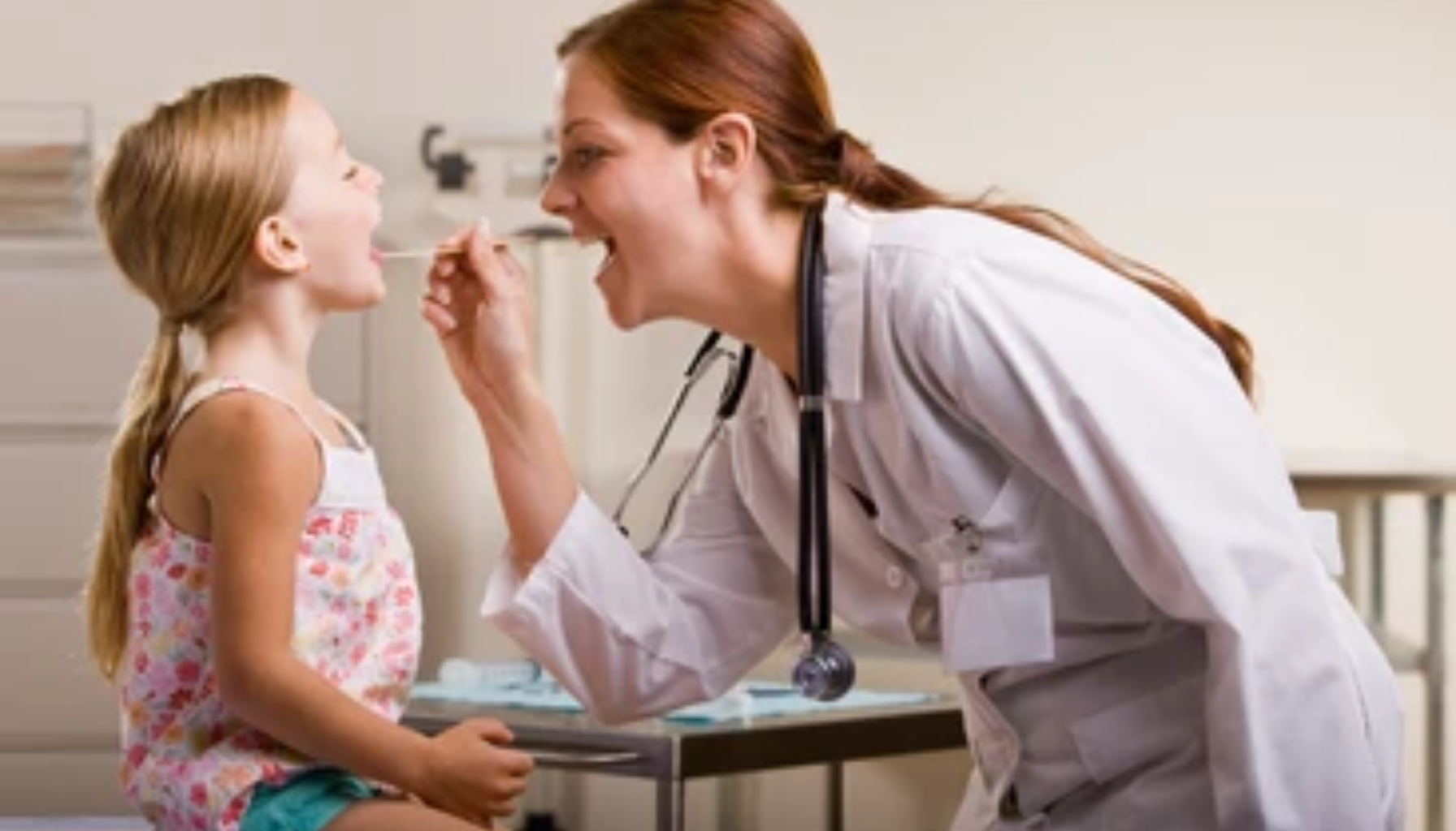 Blåtunge: Når Fargen Forteller Mer Enn Du Skulle Tro 15 Lege undersøker halsen til en liten jente med trepinne under rutinekontroll i et lyst og vennlig legekontor.
