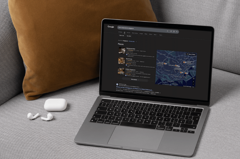 A laptop showing a Google search for "best restaurants in Singapore" with the local map pack visible, representing the importance of local search visibility in restaurant marketing.