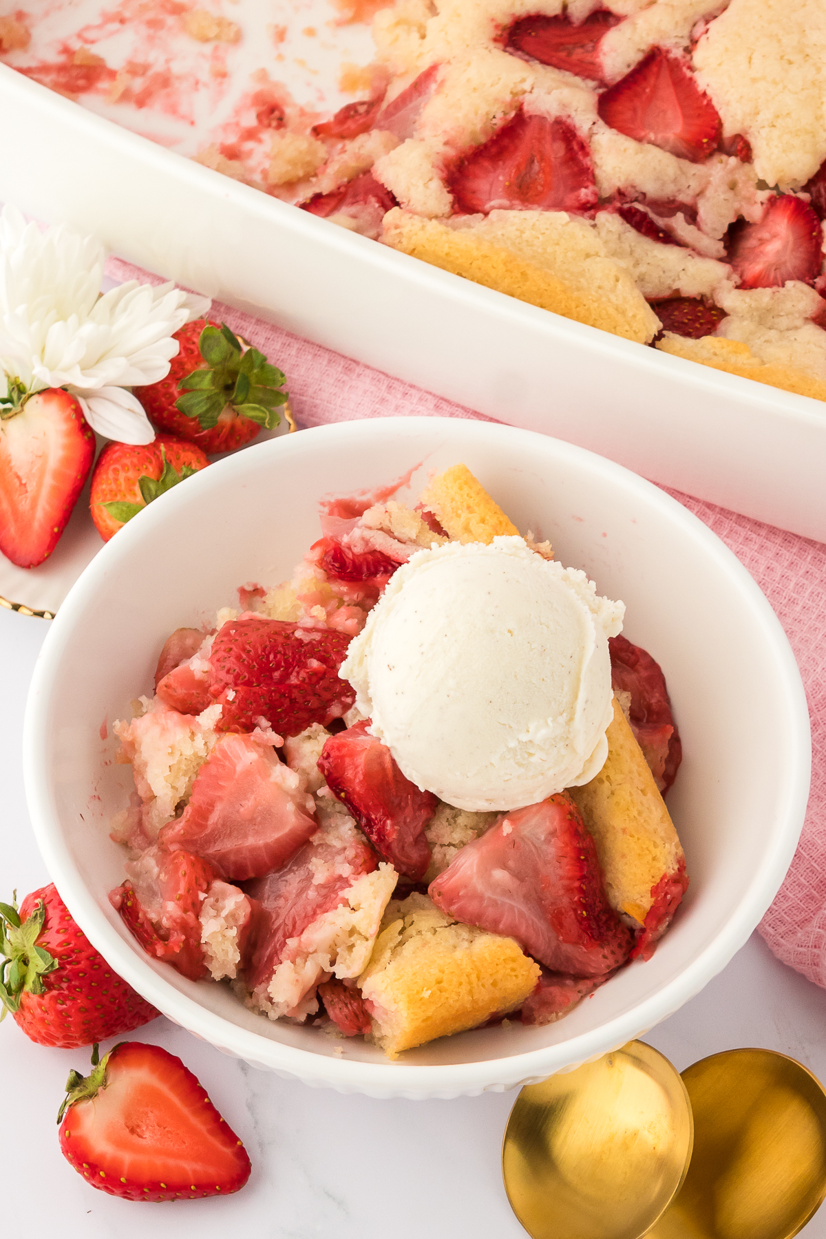bowl of strawberry cobbler topped with vanilla ice cream