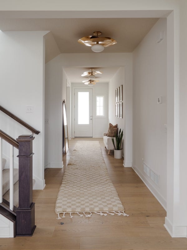 Bright hallway with a row of the Allida 1-Light Pendant ceiling light fixture, featuring modern brass accents and a minimalist design that enhances the open, airy feel.