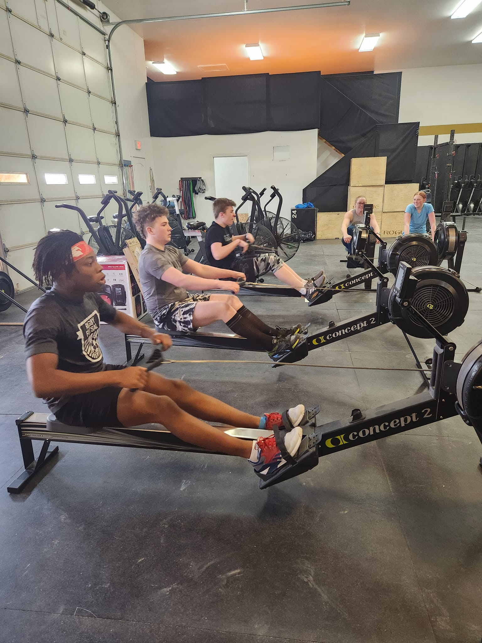 Group of people of different ages and skill levels doing CrossFit exercises in a gym, getting ready for their first visit