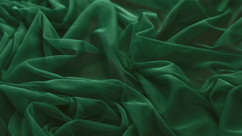 A close-up view of a dark green sheer fabric