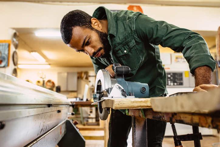 Man using a table saw. 